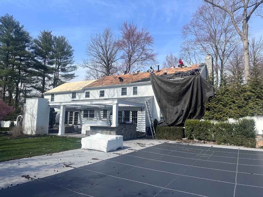 Catch tarps hung off a colonial roof to protect the driveway and patio during tear-off