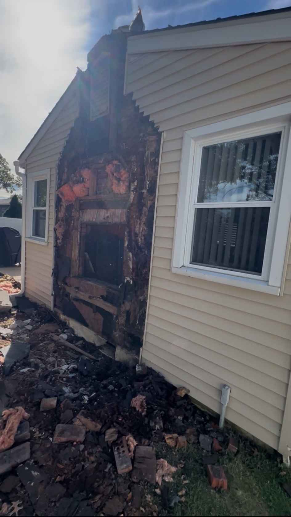 Exterior chimney brick taken down, leaving the old opening in the wall and broken brick on the ground