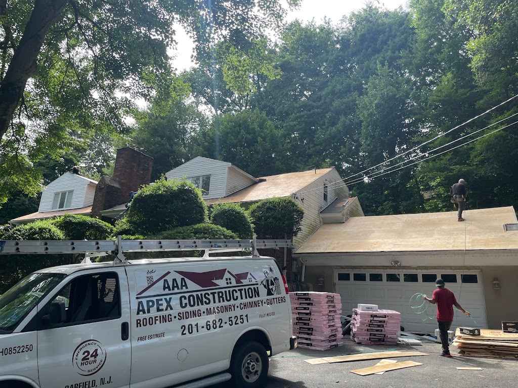 AAA Apex Construction van parked at a job with bundles of shingles staged in the driveway