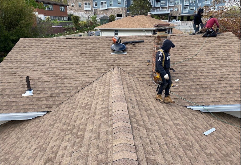 AAA Apex roofer walking the ridge of a newly installed tan architectural shingle roof
