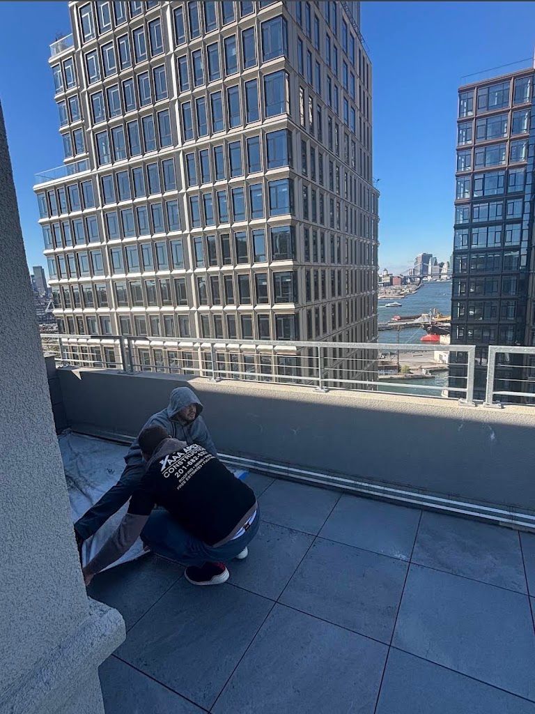 AAA Apex crew members working on a rooftop terrace between high-rise buildings