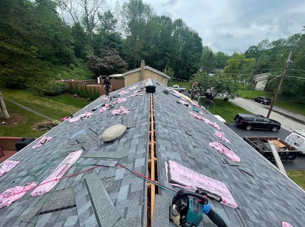 New shingles being installed up to an open ridge before the ridge vent goes on