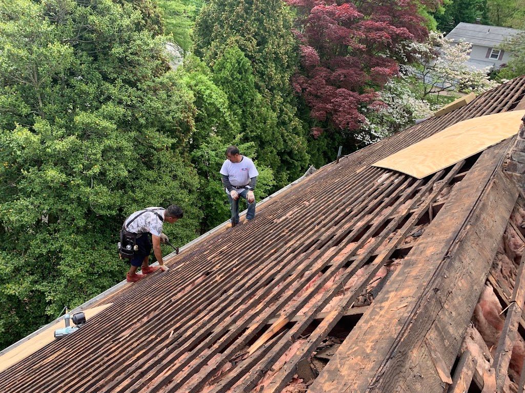 Crew removing old roofing down to the original board sheathing